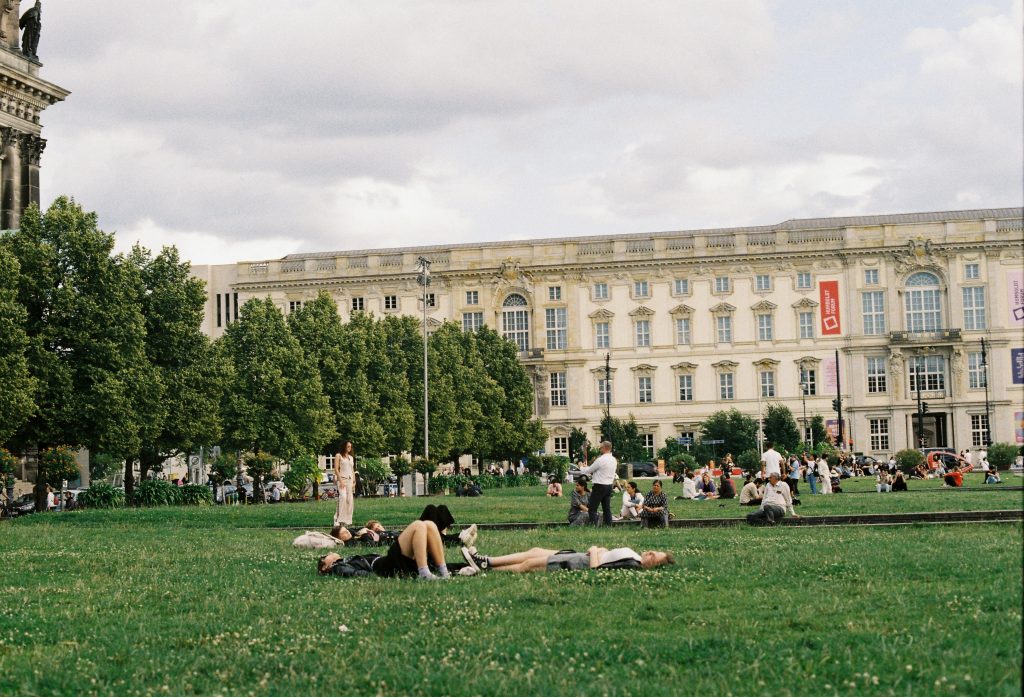 People relaxing and enjoying the day at Lustgarten park in Berlin, Germany.