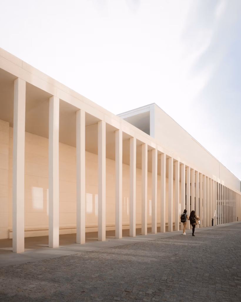A couple walks along the modern colonnade of James-Simon-Galerie in Berlin.